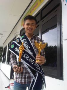 Bangun membawa piala kejuaraannya dalam kontes Kakang Mbakyu Kota Malang 2013.